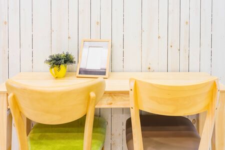 Workplace with green plant and home decor on a table and wooden wall backgroundの写真素材
