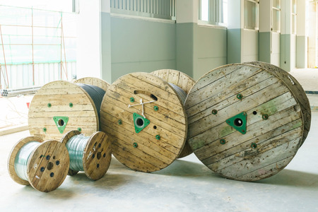 black wire electric cable with wooden coil of electric cable in construction site.の写真素材