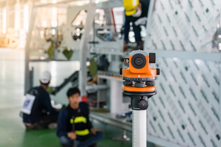 Construction surveyor equipment theodolite level tool during workers installing machine at backgroundの写真素材