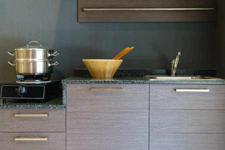 Close-up of stainless steel cooking pot on induction hob in contemporary modern home kitchen.の写真素材