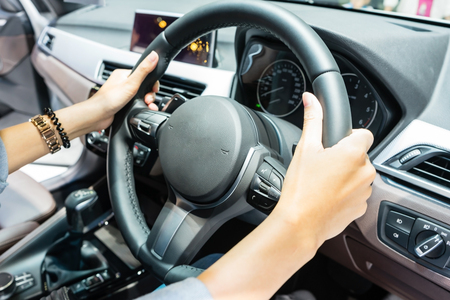 Driver's hands on the steering wheel inside of a carの写真素材