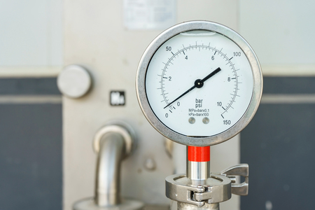 Closeup of manometer, measuring gas pressure. Pipes and valves at industrial plant.の写真素材