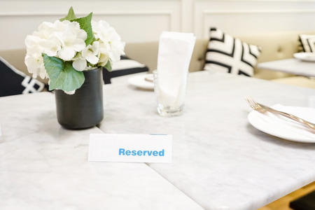 Reserved plate on a dinner table in a restaurant with elegant table settingの写真素材