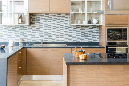 Modern, bright, clean kitchen interior with stainless steel appliances in a luxury apartment.の写真素材
