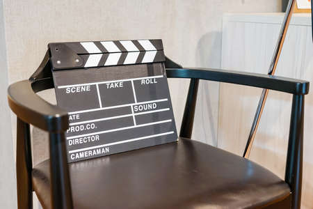 Director Chair, Movie Clapper and Megaphone in the volumetric light on wooden background.の写真素材
