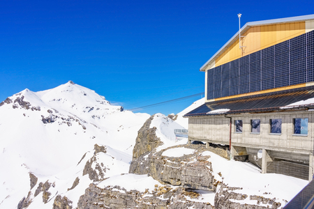 MURREN, SWITZERLAND - APRIL 12, 2018: Upper station Birg in swiss alps in Murren. Panoramic view of the high mountain top cable car station. Looking towards wengernalp train station in the background.のeditorial素材
