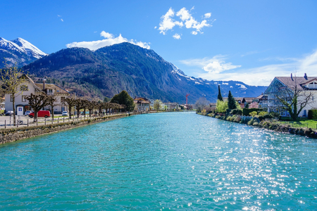Beautiful view of old town and interlaken lake canal, Switzerland. Alps mountains covered by snow and colourful of buildings in cityの写真素材