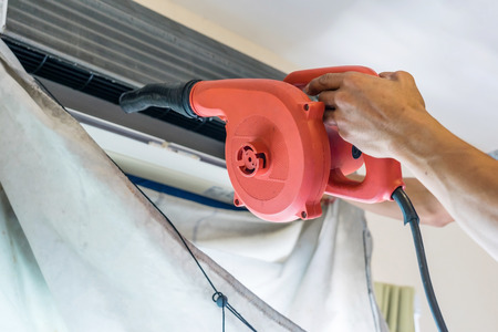 Service technician is cleaning, repair and maintenance of air conditioner