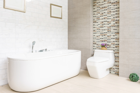 Modern bathroom interior with minimalistic shower and lighting, white toilet, sink and bathtubの写真素材