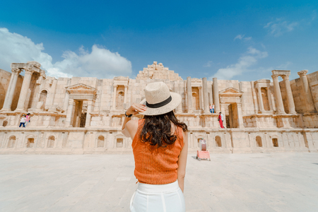 Back view of Asian young woman standing in front of South roman theatre, Jerash, Jordanの写真素材