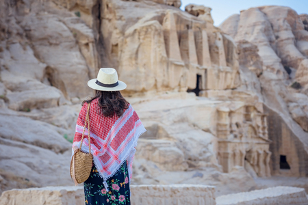 Young woman tourist in colorful dress and hat walk around the Canyon Siq (Al-Siq) located at Rose city - Petra, Jordan.の写真素材