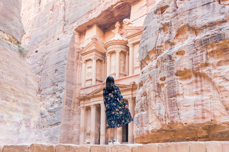 Asian young woman tourist in color dress and hat enjoying the Treasury, Al Khazneh in the ancient city of Petra, Jordanの写真素材