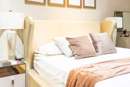 Beautiful luxury comfortable pillow on bed with light lamp furniture decoration interior of bedroomの写真素材