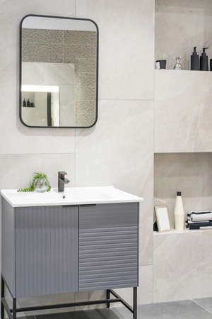 Bathroom interior with white wall, vintage furniture, towels, toilet and sinkの写真素材