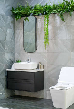 Bathroom interior with white wall, vintage furniture, towels, toilet and sinkの写真素材