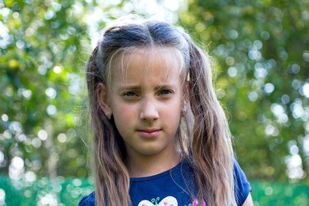 Angry little girl with long blond hair and blue eyesの写真素材