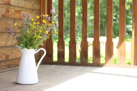 Summer bouquet in a white pitcher on wooden terraceの写真素材