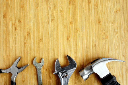 Pliers, spanner, adjustable wrench and hammer on workbench
