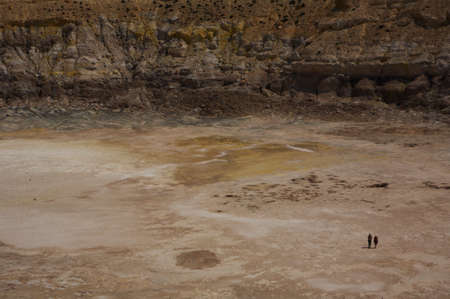 Two people walking down in a vulcano holeの写真素材
