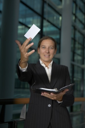 a young good looking business woman holding up her cardの写真素材