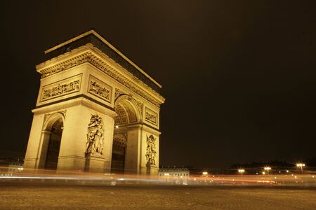 Arc de Triomphe at night with cars driving byの写真素材