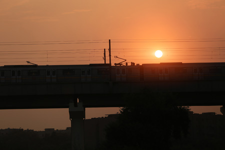 Metro train entering in to the station during sunset silhouette.の写真素材