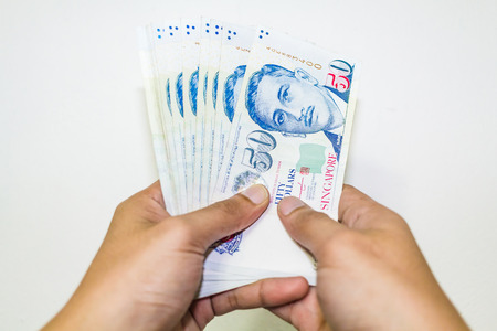 Singapore Currency with Hand Isolated in white background, Singapore Dollar, Banknote Singapore