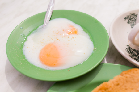 Half-boiled eggs, Traditional Singapore Breakfast called Kaya Toast, Original bread toast with kaya a local jam made from eggs, sugar and coconut milk. The fractal on the cup is generic printの写真素材