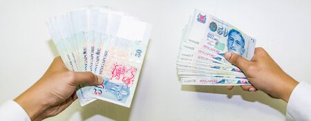 Singapore Currency with Hand Isolated in white background, Singapore Dollar, Banknote Singapore,...