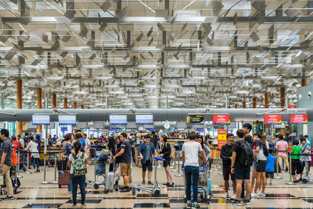 Singapore - July 8, 2017: Visitors walk around Departure Hall in Changi Airport. It has 3 passenger...