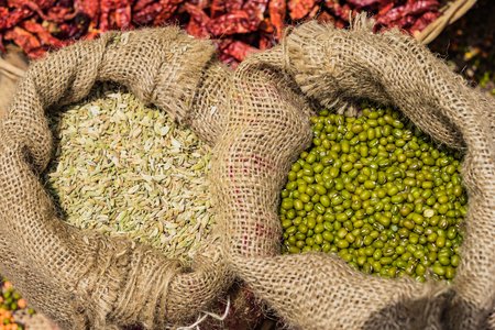 Sack of dried green beans on the wooden table background at market