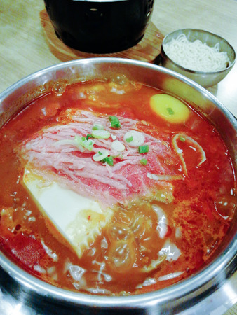Delicious Korean food Yukgaejang spicy beef soup, Yukgaejang Hot pot is Korean stew made with kimchi, noodles, cheese, ham, sausage, mussels, prawn and vegetablesの写真素材