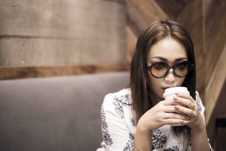 Asian woman  drinking coffee in a cafeの写真素材