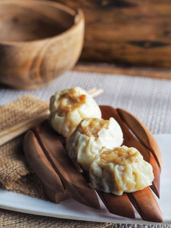 steamed dumpling dimsum in traditional bamboo steamer on wooden background selective focus on dimsumの写真素材