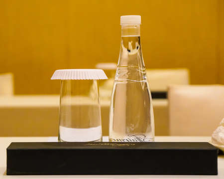 conference hall/ Empty small conference hall with a large wooden table. Notebooks and mineral water on the table. Retro styleの写真素材