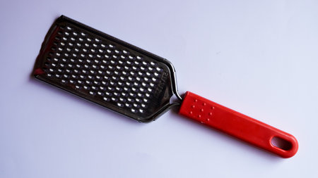 A closeup shot of a red plastic grater on a white backgroundの写真素材