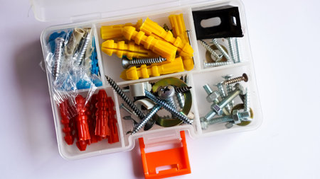 Assorted screws, bolts, nuts and dowels in a plastic box.の写真素材