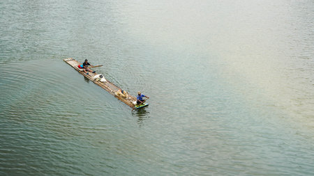 Aerial view of two men rowing on a boat in the river