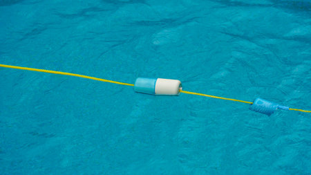 A plastic border of water on the edge of a swimming pool with a yellow line