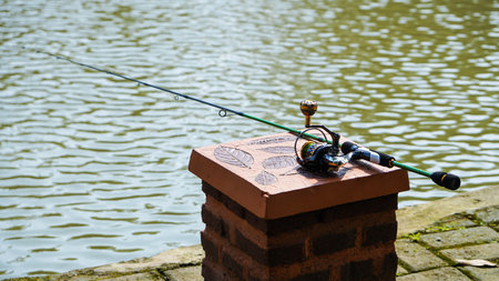 Fishing rod with reel on the top of a brick wall.の写真素材