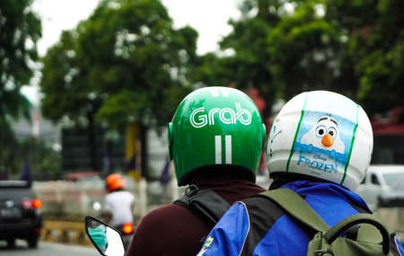 Jakarta 11th November 2021, Congested traffic, Grab driver on phone. Grab is a technology company that offers wide range of ride-hailing and logistics services in selective focusの写真素材