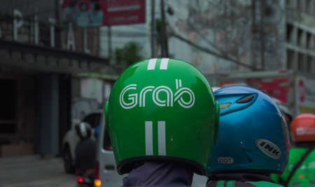 Jakarta 11th November 2021, Congested traffic, Grab driver on phone. Grab is a technology company that offers wide range of ride-hailing and logistics services in selective focusの写真素材