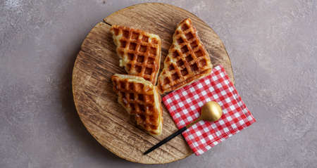 Jakarta 11th November 2021, Asian cute girl biting Stack of Croissant Waffle or Croffle served in round wood surface plate. Selective focus image.の写真素材