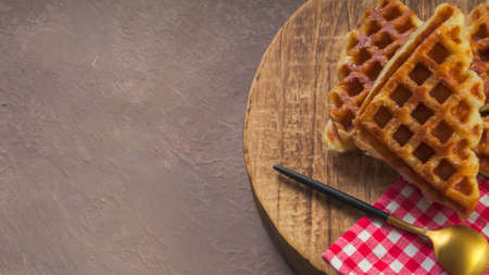 Stack of Croissant Waffle or Croffle served in round wood surface plate. Selective focus image.の写真素材