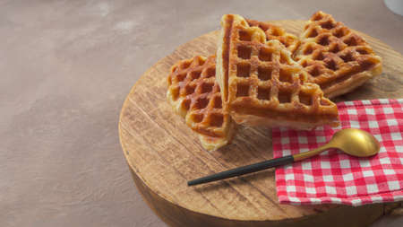 Stack of Croissant Waffle or Croffle served in round wood surface plate. Selective focus image.の写真素材