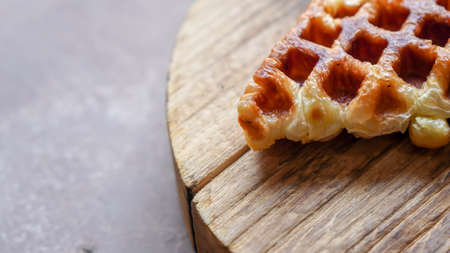 Stack of Croissant Waffle or Croffle served in round wood surface plate. Selective focus image.の写真素材