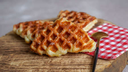 Stack of Croissant Waffle or Croffle served in round wood surface plate. Selective focus image.の写真素材