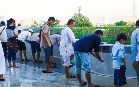 Unidentified Muslim men washing their hands and abultion in front of the mosque.のeditorial素材