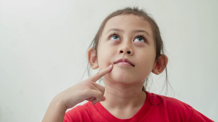 Little Asian Girl looks like thinking somethingの写真素材