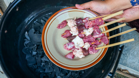 Skewers of pork and beef in a bowl on the grill.の写真素材